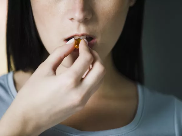 Healthy woman taking a pill