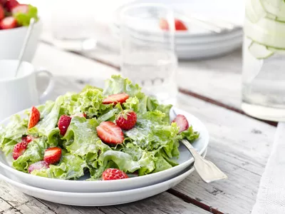 Strawberry caesar salad on a white plate