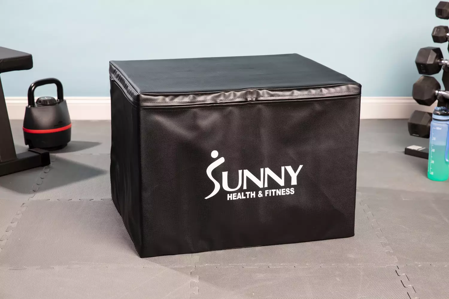 Sunny Health & Fitness High-Capacity Wooden Plyo Box on floor near fitness equipment