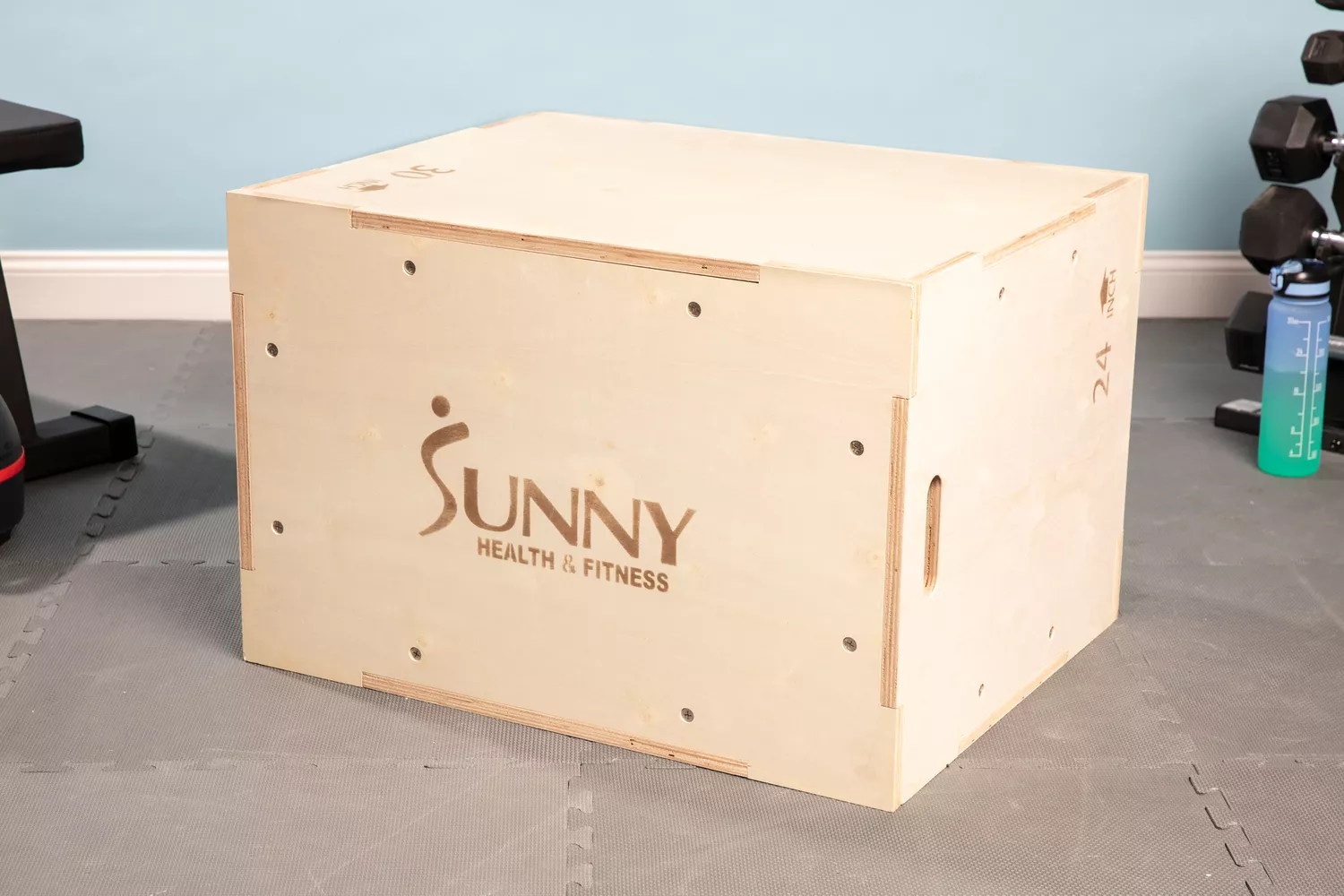 Sunny Health & Fitness High-Capacity Wooden Plyo Box on floor near fitness equipment