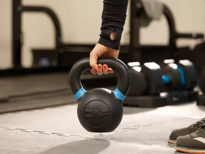 Person picking up a CAP Barbell Cast Iron Competition Kettlebell Weight