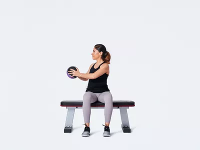 woman doing seated work with medicine ball