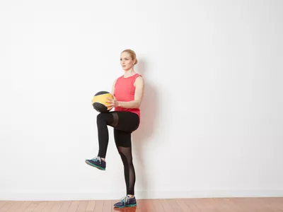 woman doing knee lifts with medicine ball