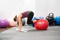 Person exercising using GoFit Pro Grade Stability Ball on gym mats