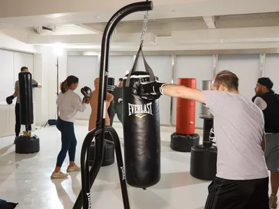 People punching several top punching bags