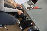 Hand adding weight To Core Home Fitness Twistlock Dumbells