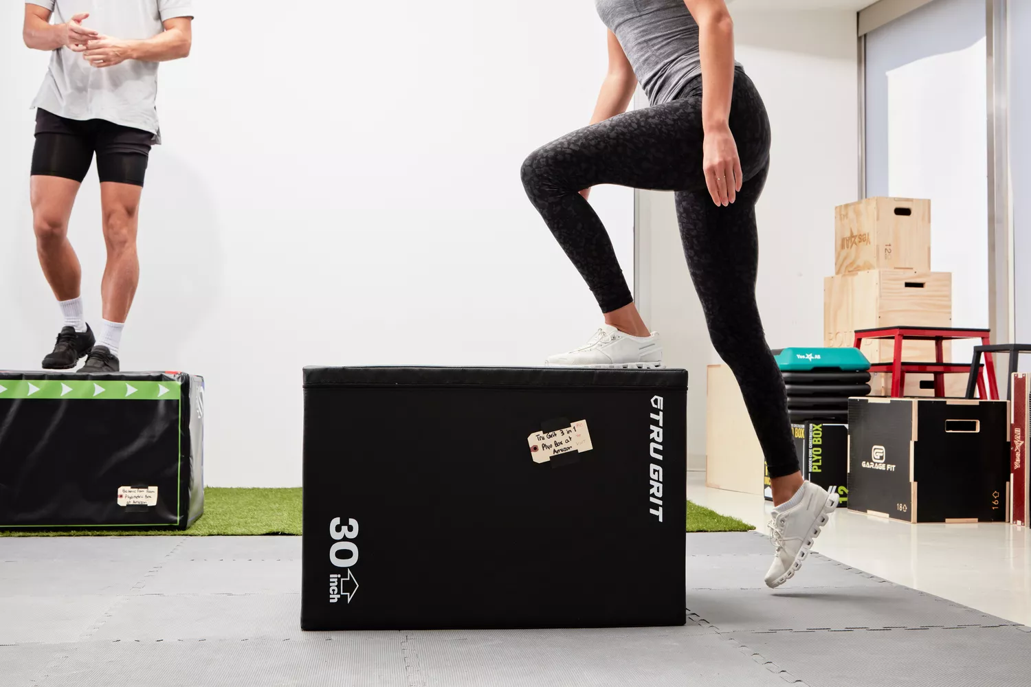 Two people stepping up onto plyo boxes