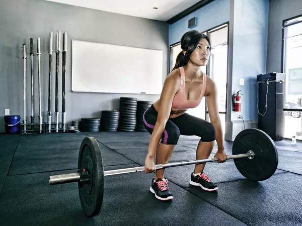 Woman doing deadlifts in a gym