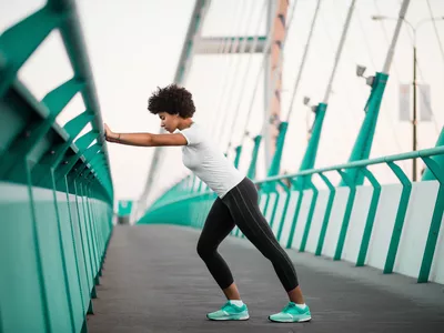 Athletic, young woman exercising on city bridge