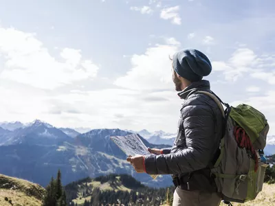 Austria, Tyrol, young man with map in mountainscape