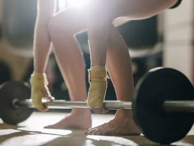 Person lifting weights barefoot