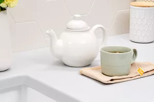 teapot and cup of tea with herbs in the kitchen