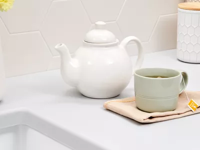 teapot and cup of tea with herbs in the kitchen