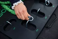 A closeup of a person hooking a resistance band to the BodyBoss 2.0 Full Portable Home Gym's board.