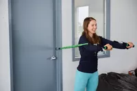 A person using a door and the BodyBoss 2.0 Full Portable Home Gym to work arm muscles.