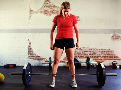 a woman weightlifting in a gym