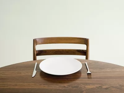 Empty plate with knife and fork on table.