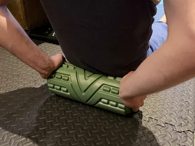 A person exercises using the Premvida 3-Speed Vibrating Foam Roller.
