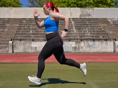 Woman running outside next to a track