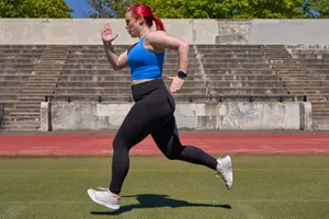 Woman running outside next to a track