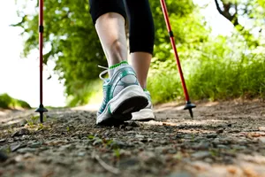 close-up of woman's ankles walking outside with hiking poles