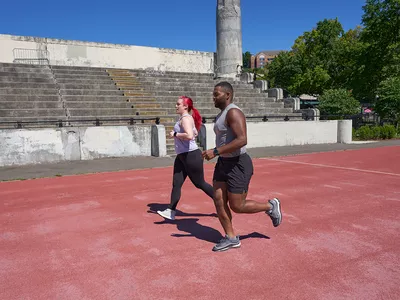 Woman and man running on a trac