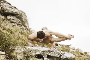 Man practicing yoga on a rock, South Africa