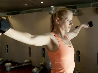 Young woman exercising with dumbbells