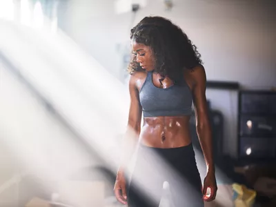muscular african american woman sweating from work out in home gym
