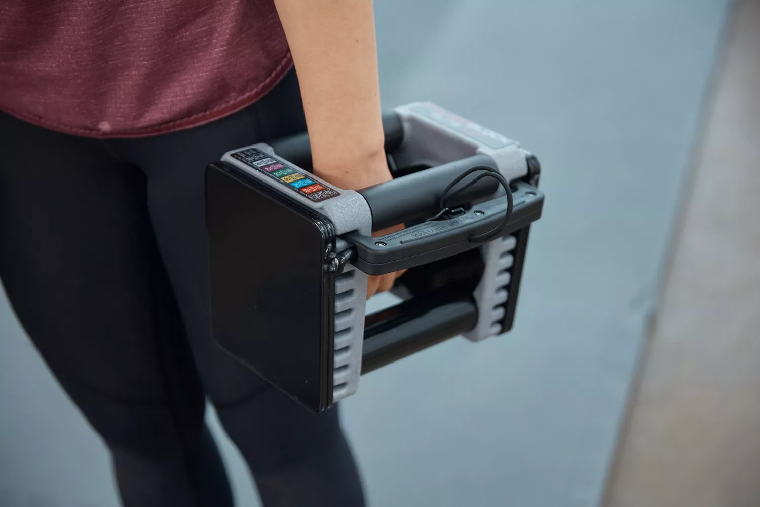 A person holds the POWERBLOCK Elite EXP Adjustable Dumbbell