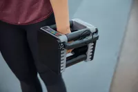 A person holds the POWERBLOCK Elite EXP Adjustable Dumbbell