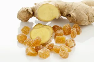 Sliced ginger and pieces of candied ginger on white background, close up