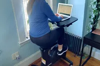 Person using Flexispot Home Office Height Adjustable Cycle Desk Bike while working on laptop