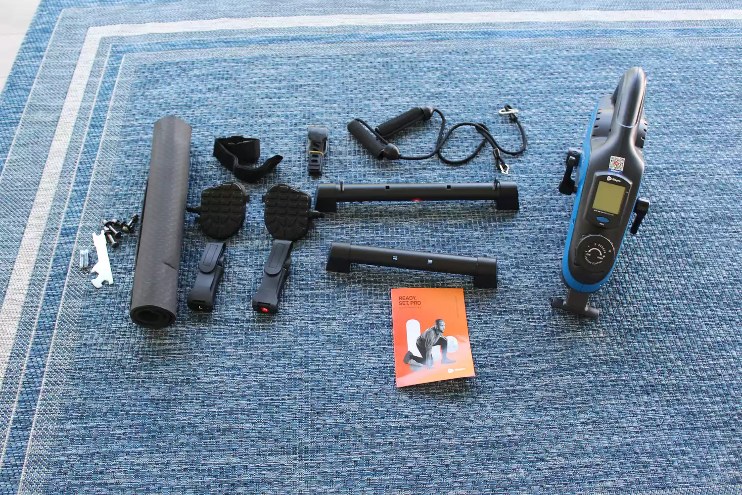 Parts of LifePro FlexCycle Exercise Bike Under Desk Bike Pedal Exerciser displayed on mat