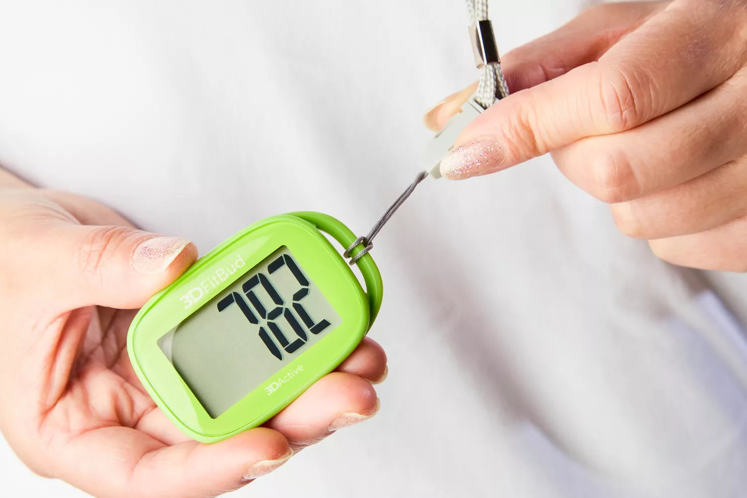 A person pulls a strap attached to the 3DActive 3DFitBud Simple Step Counter 3D Pedometer