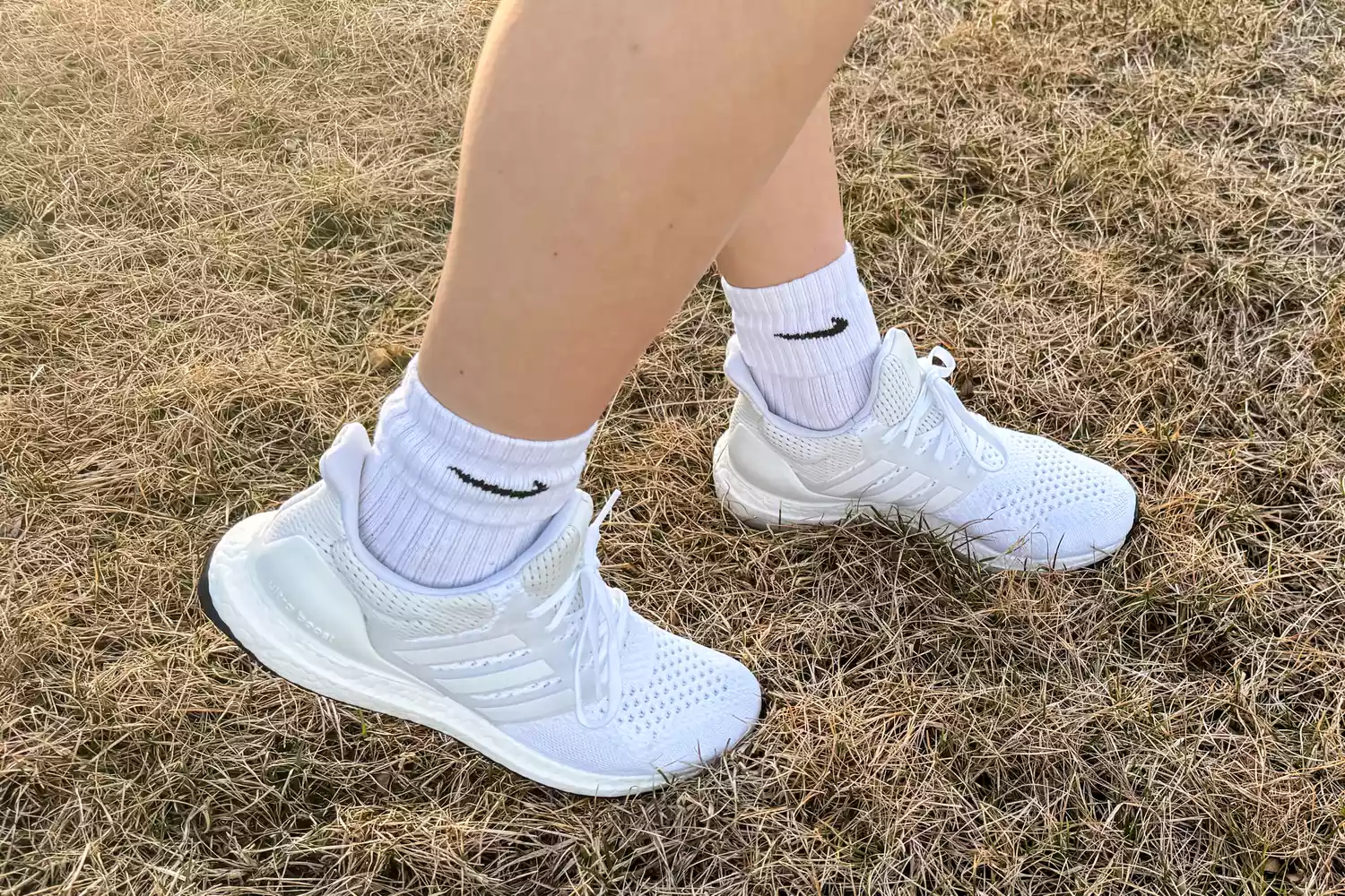 A close-up of the Adidas Women's Ultraboost 1.0 Shoes worn in grass