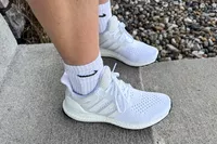 The Adidas Women's Ultraboost 1.0 Shoes worn on a concrete step