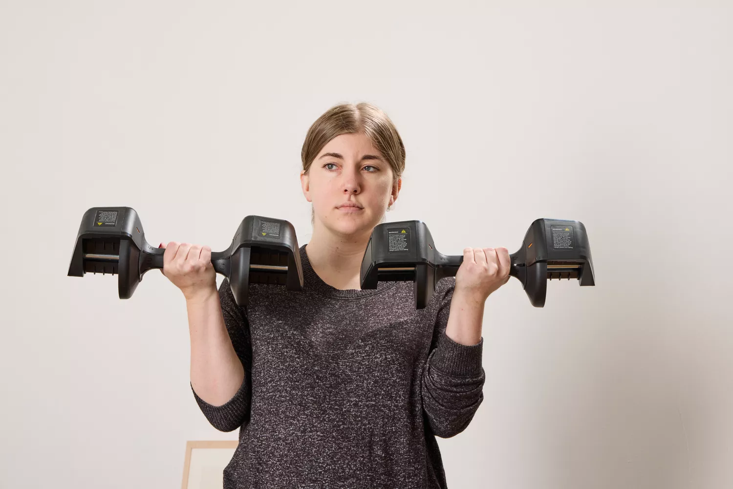 A person lifts the All in Motion 25 lb Adjustable Dumbbells