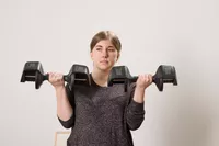 A person lifts the All in Motion 25 lb Adjustable Dumbbells