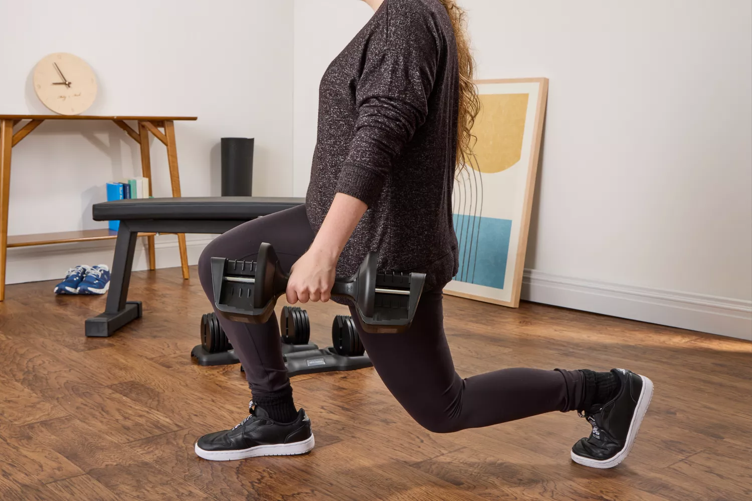 A person does lunges while holding the All in Motion 25 lb Adjustable Dumbbell