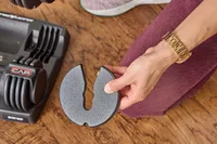 A person holds up a CAP Barbell 25 lb. Adjustable Dumbbell weight