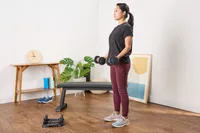 A person exercises with the CAP Barbell 25 lb. Adjustable Dumbbells