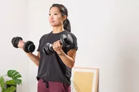 A person lifts up the CAP Barbell 25 lb. Adjustable Dumbbells