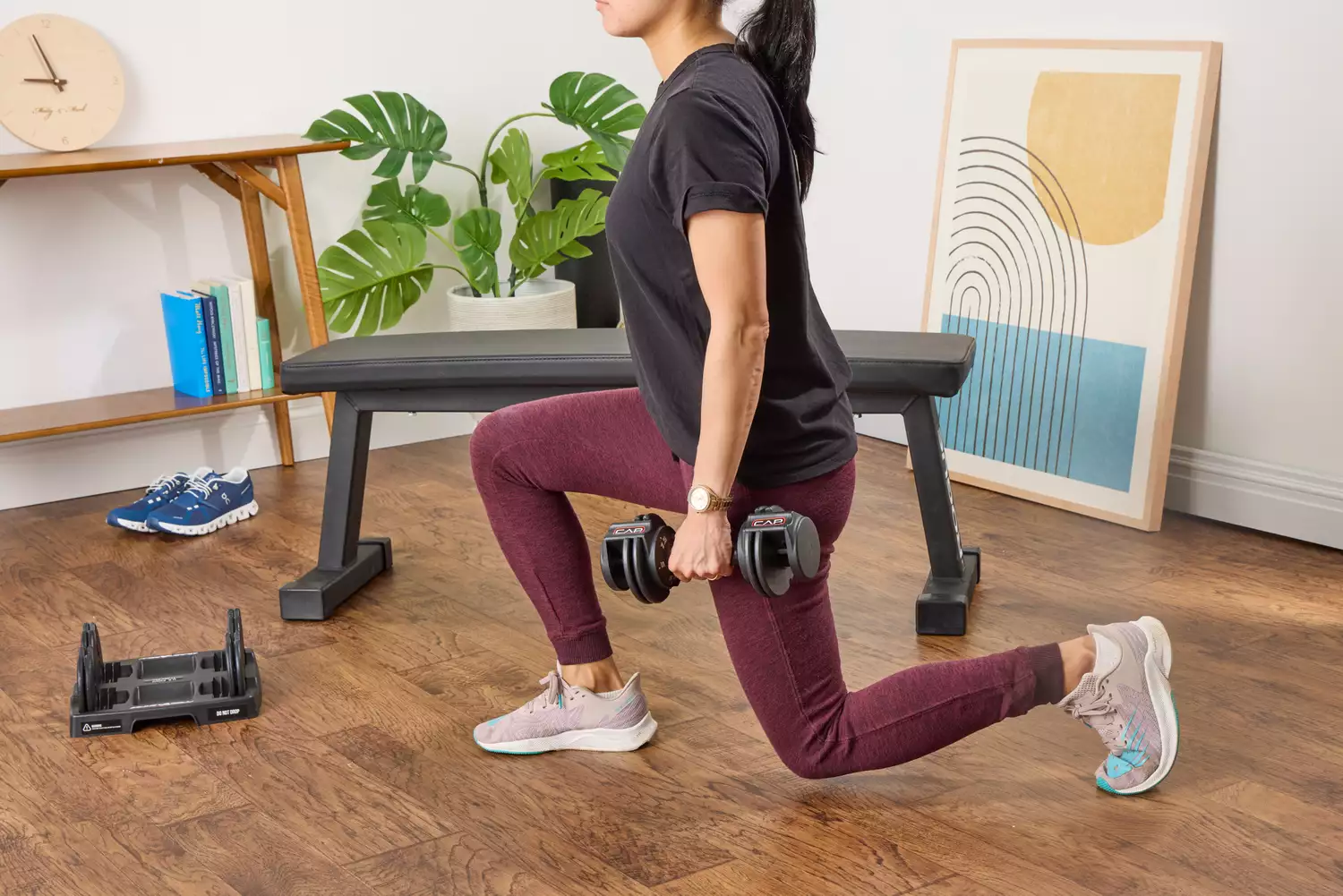 A person lunges while holding the CAP Barbell 25 lb. Adjustable Dumbbell