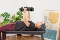 A person lifts the CAP Barbell 25 lb. Adjustable Dumbbell