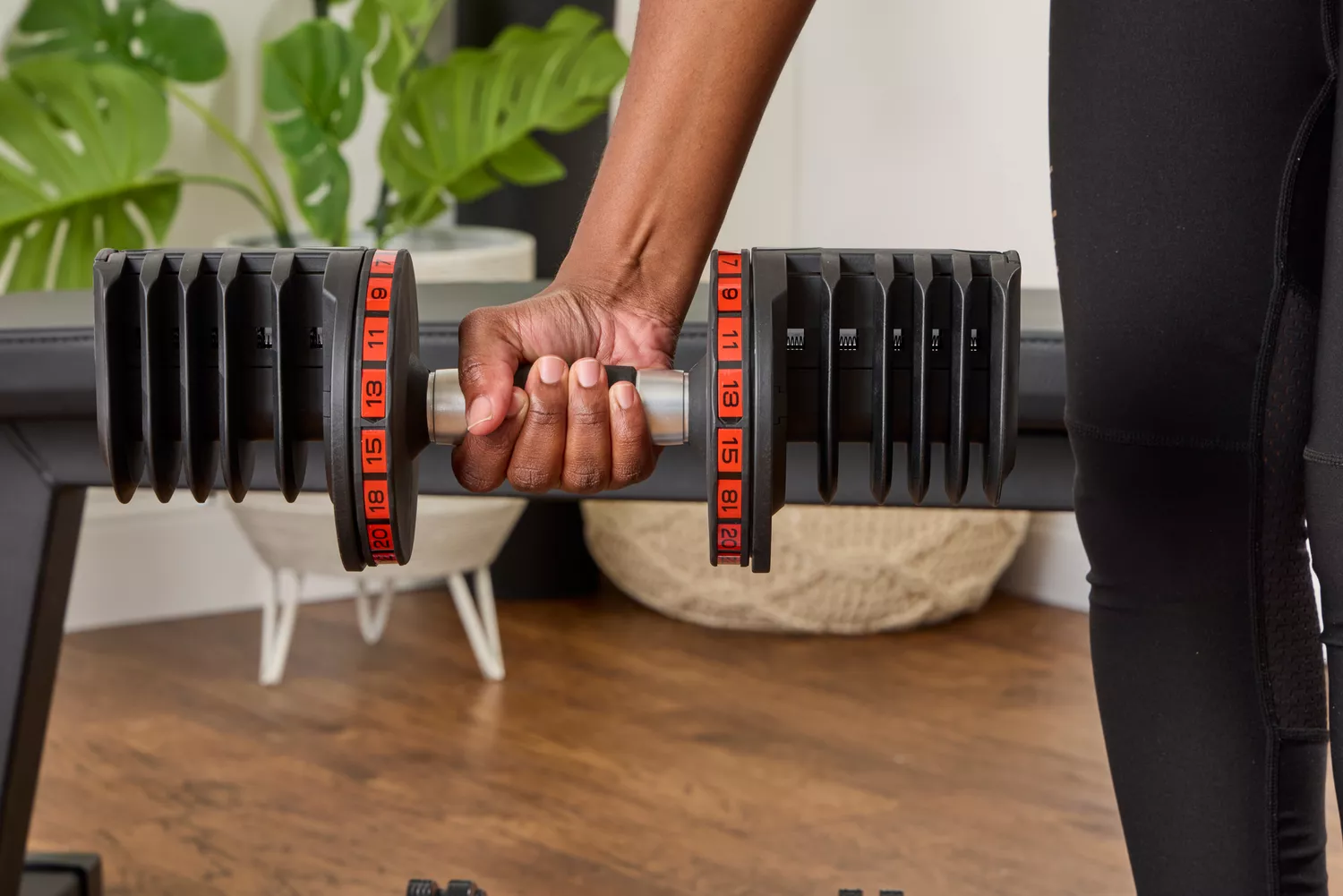A person holds the Non Zero Gravity 55 lbs PowerDyne Adjustable Dumbbell