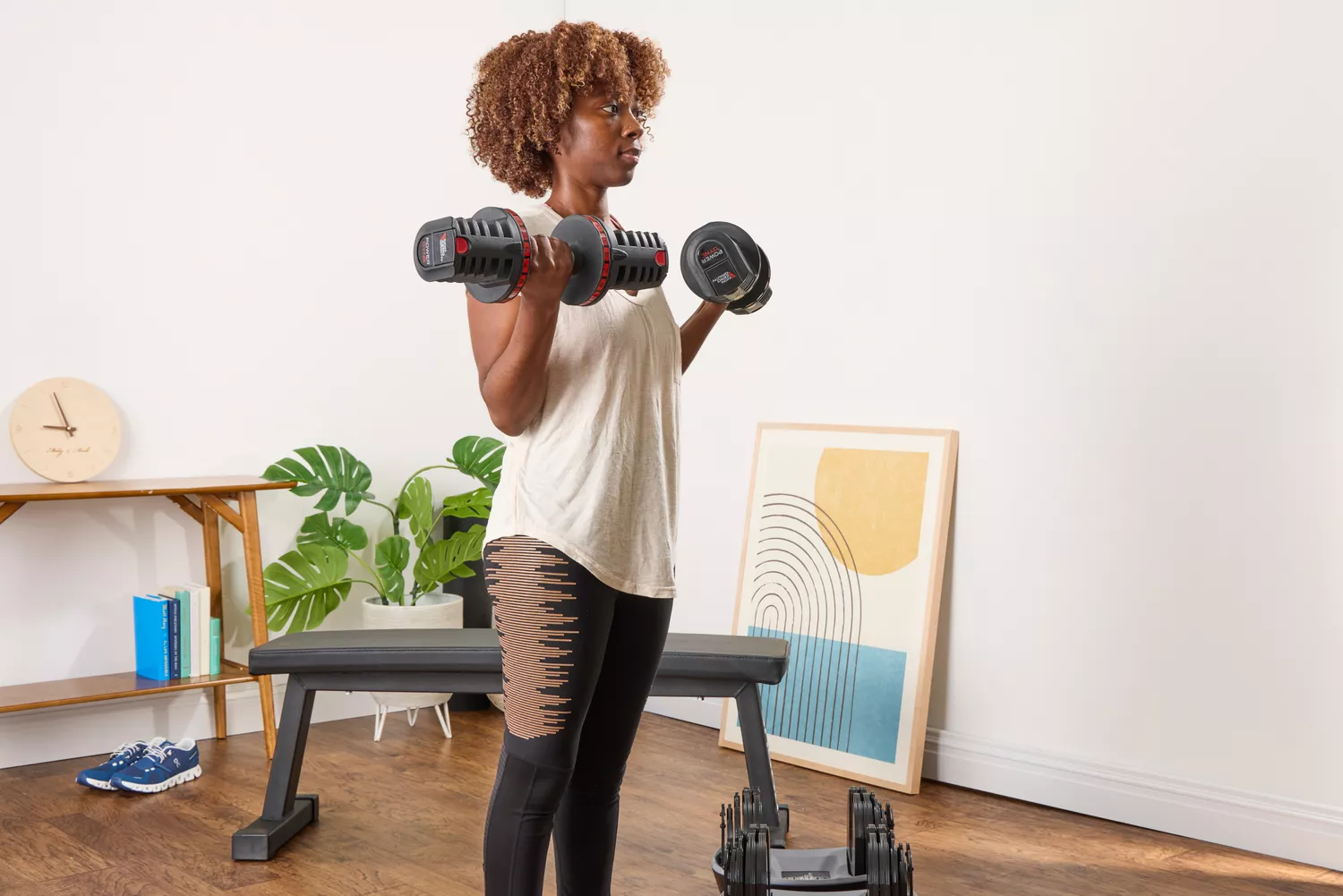 A person lifts the Non Zero Gravity 55 lbs PowerDyne Adjustable Dumbbells