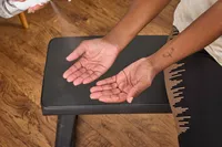 A person prepares to lift the Non Zero Gravity 55 lbs PowerDyne Adjustable Dumbbells