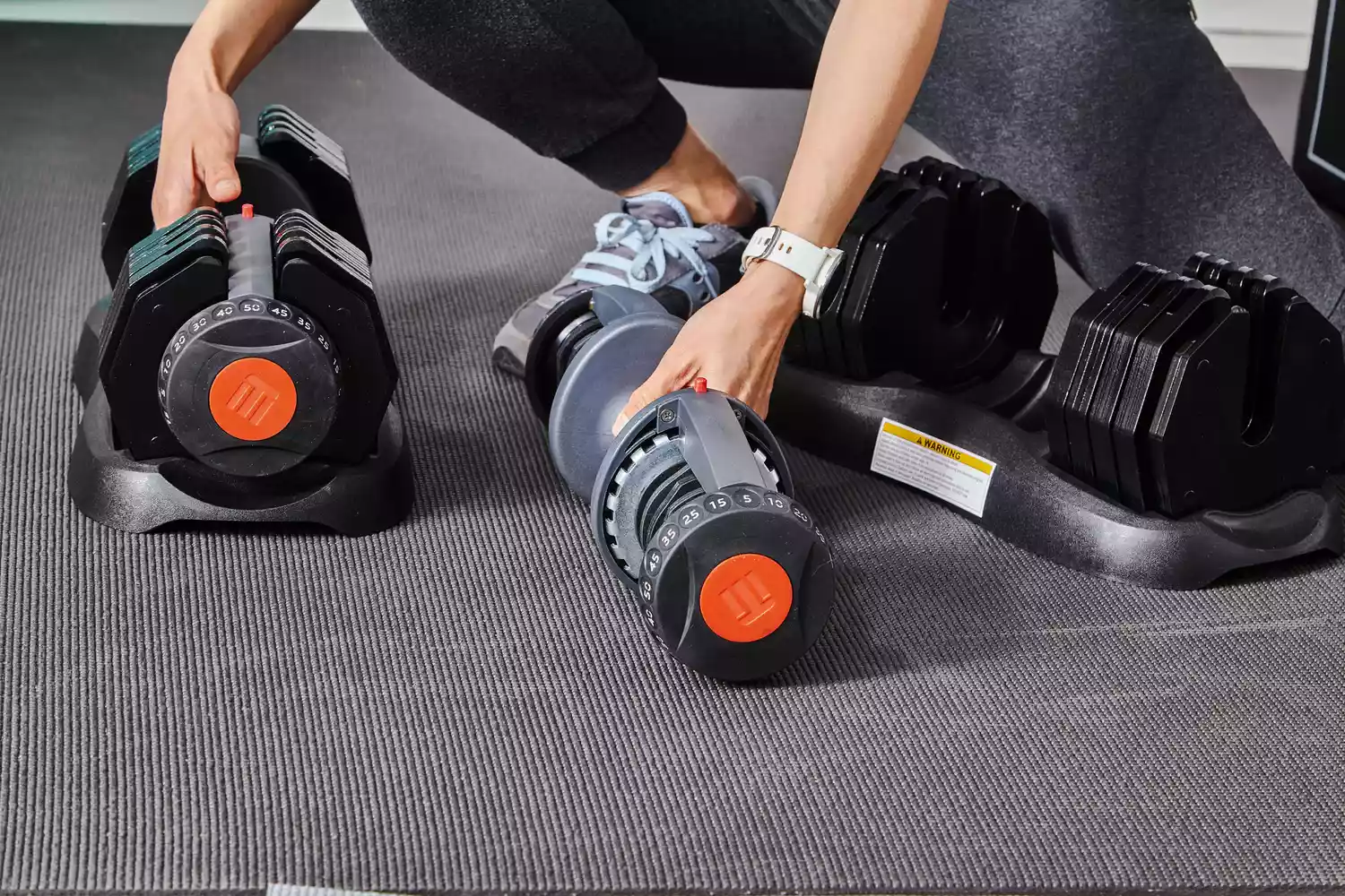 Hand preparing to lift ETHOS 50 lb. Selectable Dumbbells