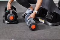 Hand preparing to lift ETHOS 50 lb. Selectable Dumbbells